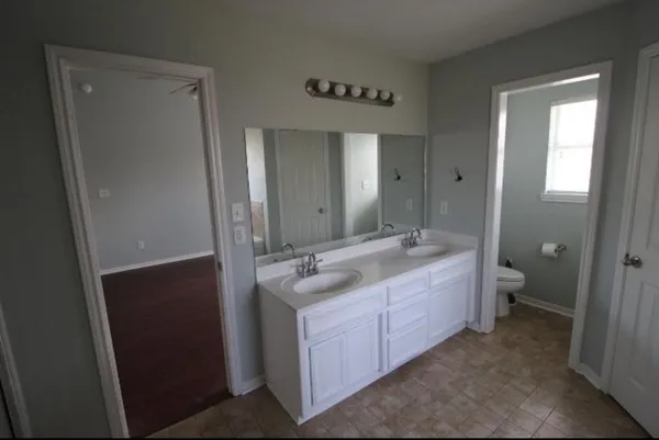 a spacious bathroom with a granite countertop sink mirror and a bathtub