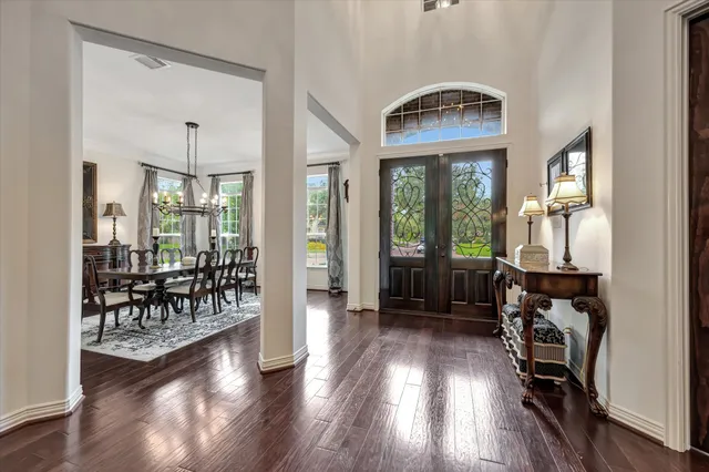 a dining room with furniture a chandelier and wooden floor
