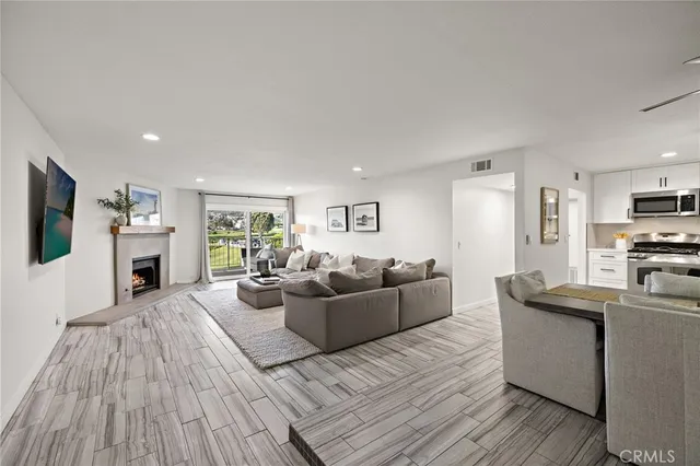 a living room with furniture a flat screen tv and a wooden floor