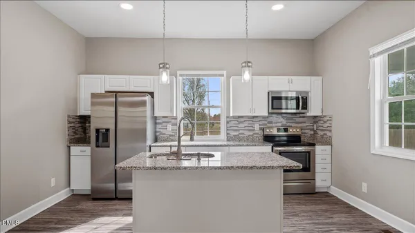 a kitchen with stainless steel appliances a sink stove refrigerator and cabinets