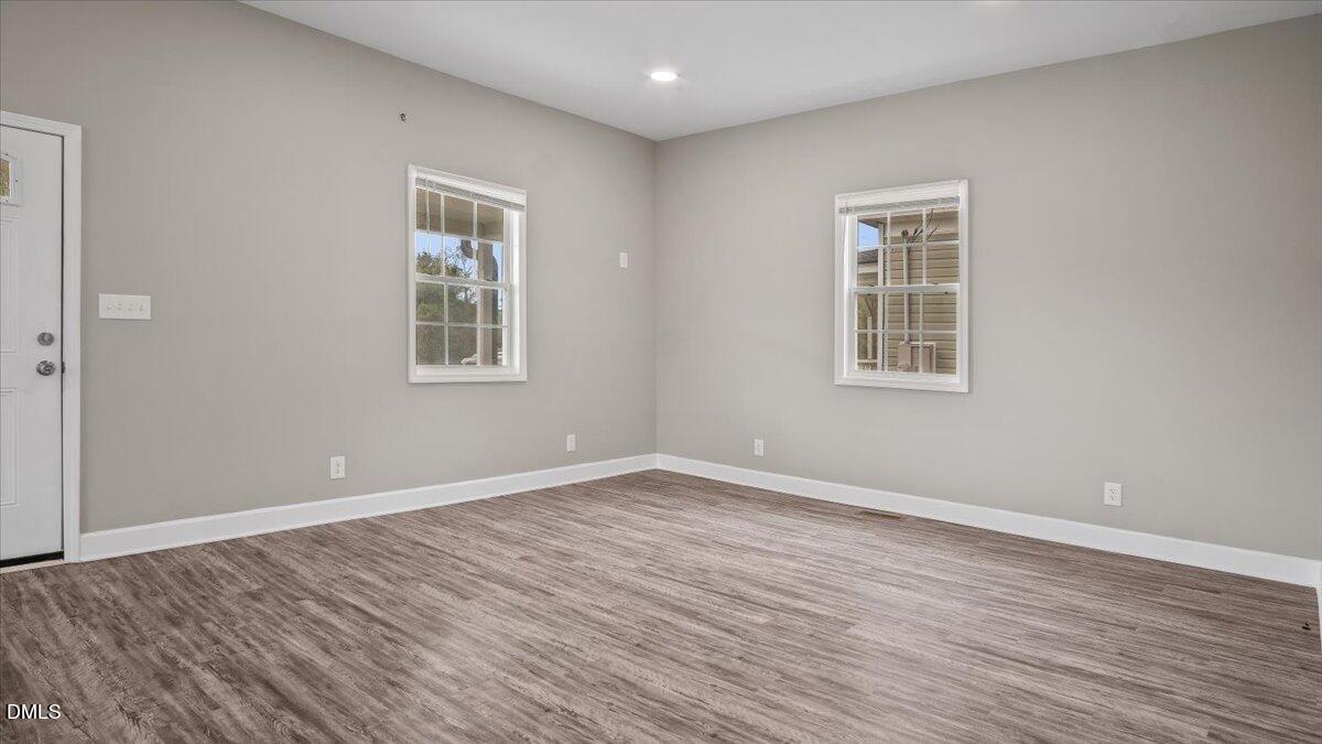 1284 Railroad Road Henderson, NC 27536 - Photo 11 of 35 an empty room with wooden floor and windows