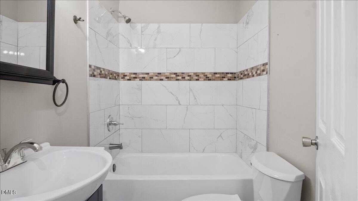 1284 Railroad Road Henderson, NC 27536 - Photo 21 of 35 a bathroom with a white bath tub sitting next to a white sink and a shower