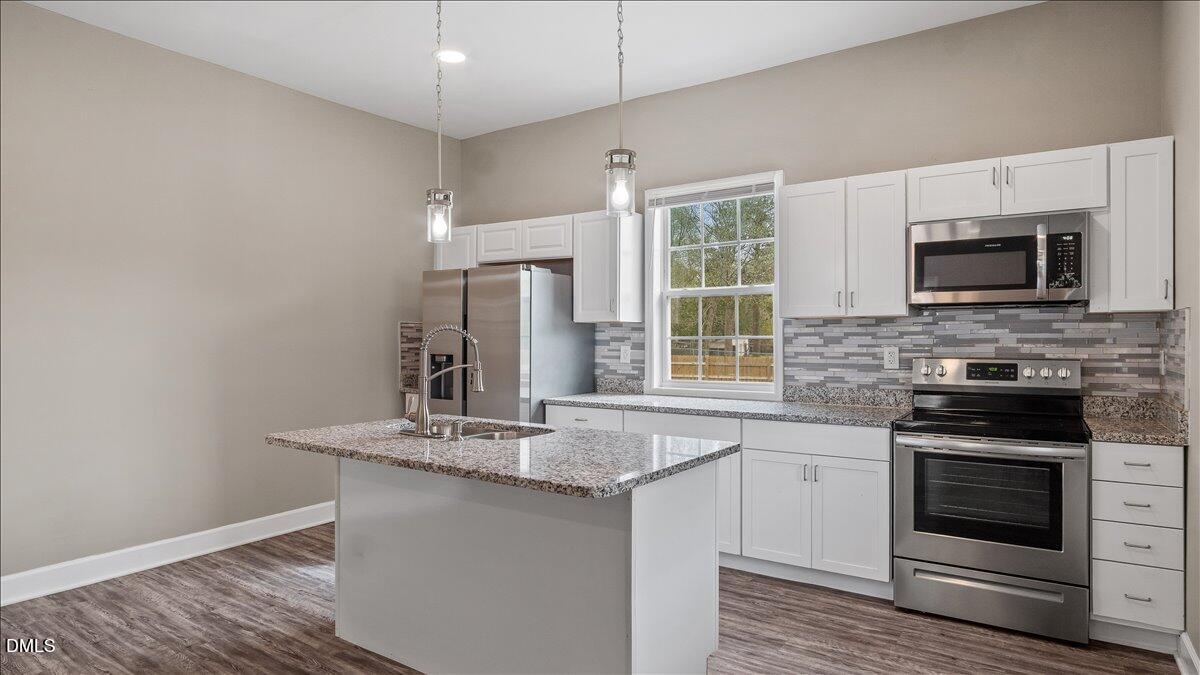 1284 Railroad Road Henderson, NC 27536 - Photo 3 of 35 a kitchen with stainless steel appliances a stove microwave and sink