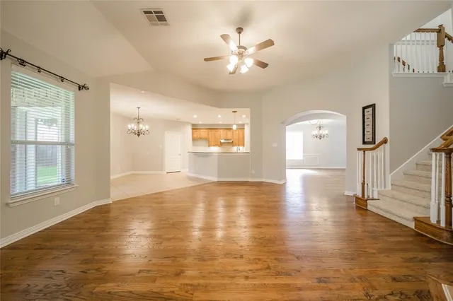 a view of an empty room with window and wooden floor
