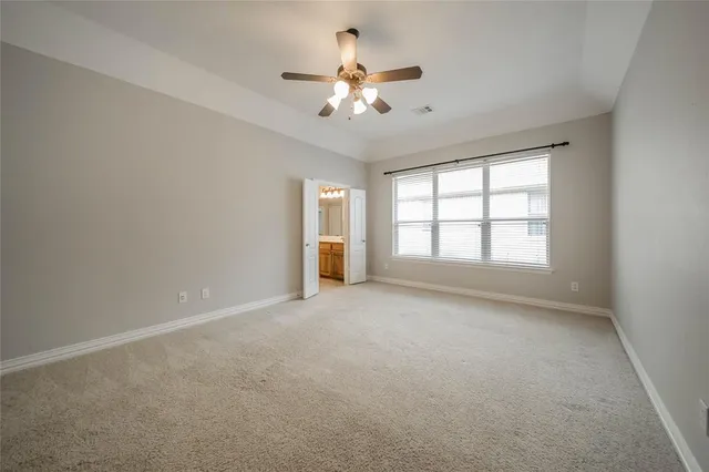 a view of an empty room and chandelier fan