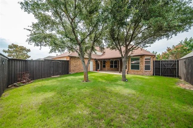a backyard of a house with wooden fence