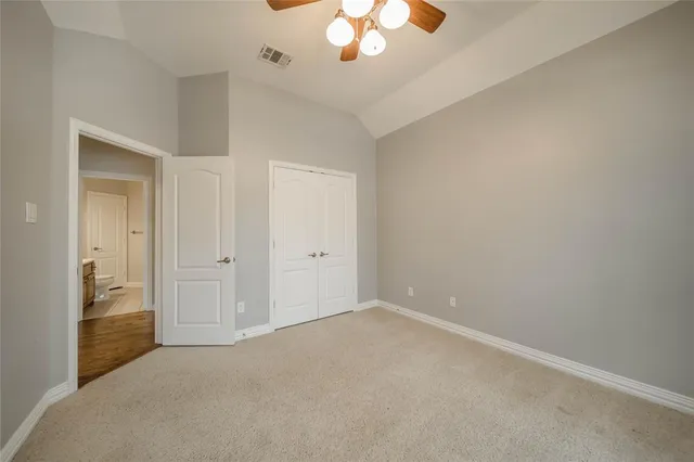 a view of an empty room with a chandelier fan
