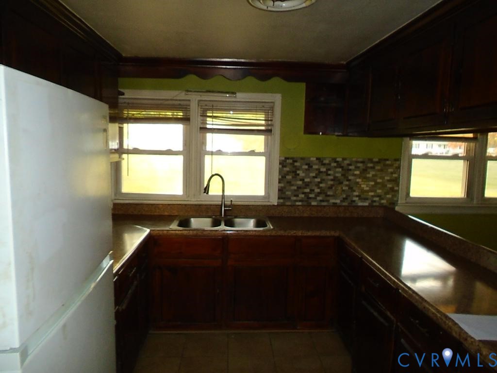 16203 West Patrick Henry Road Montpelier, VA 23192 - Photo 20 of 23 U-shaped kitchen featuring dark wood cabinetry, a