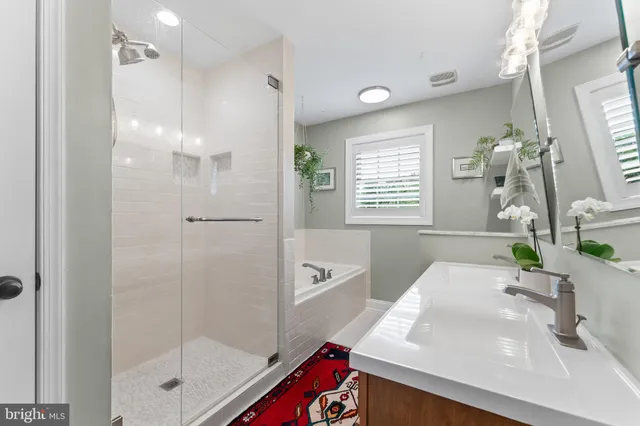 a bathroom with a bathtub a sink a large mirror and shower