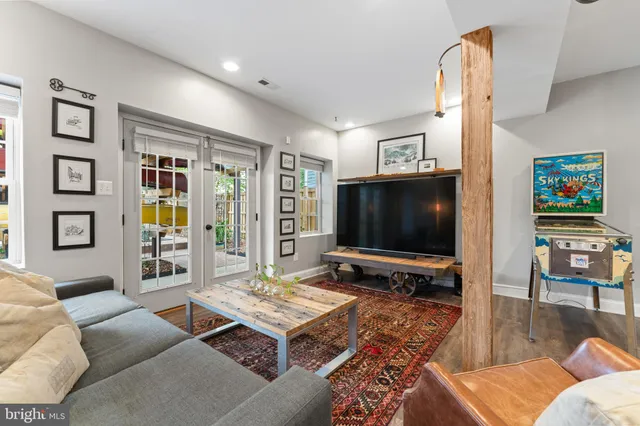 a living room with furniture a flat screen tv and a floor to ceiling window