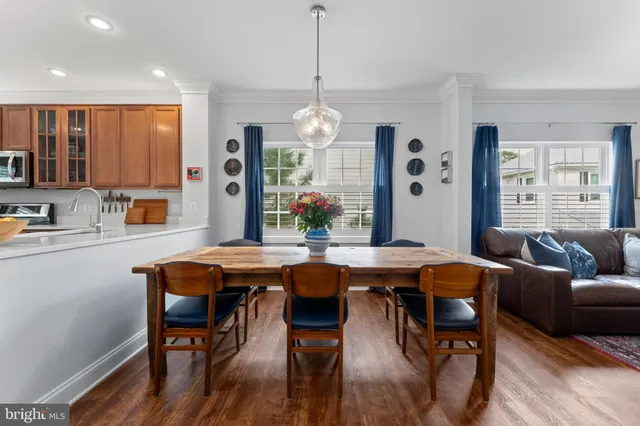 a dining room filled chandelier and wooden floor