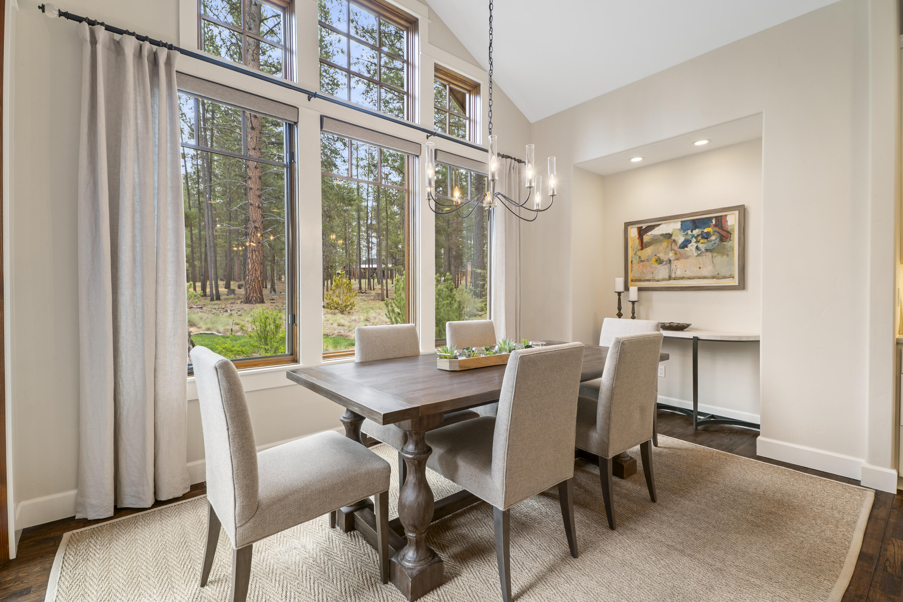 56155 Sable Rock Loop, Unit 277 Bend, OR 97707 - Photo 19 of 63 An inviting dining space framed by soaring windows and peaceful forest views, seamlessly connecting indoor and outdoor living with direct patio access and abundant natural light.