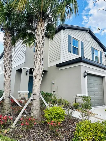 a view of a house with a yard and potted plants