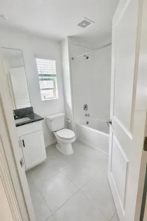 a bathroom with a toilet a sink a bath tub and a window