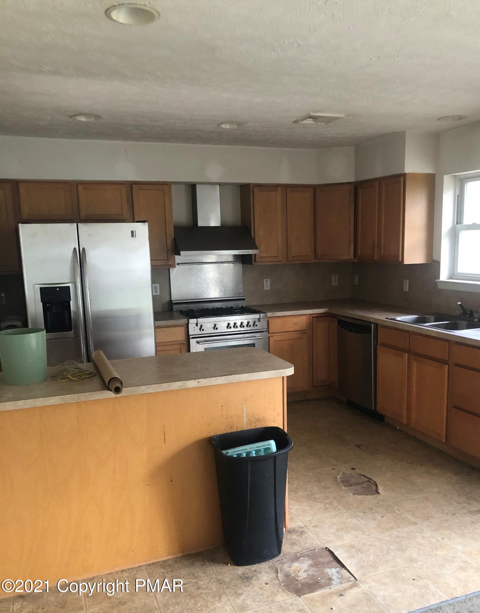 3240 Red Run Road Pocono Summit, PA 18346 - Photo 2 of 15 a kitchen with stainless steel appliances granite countertop a sink a stove and a refrigerator