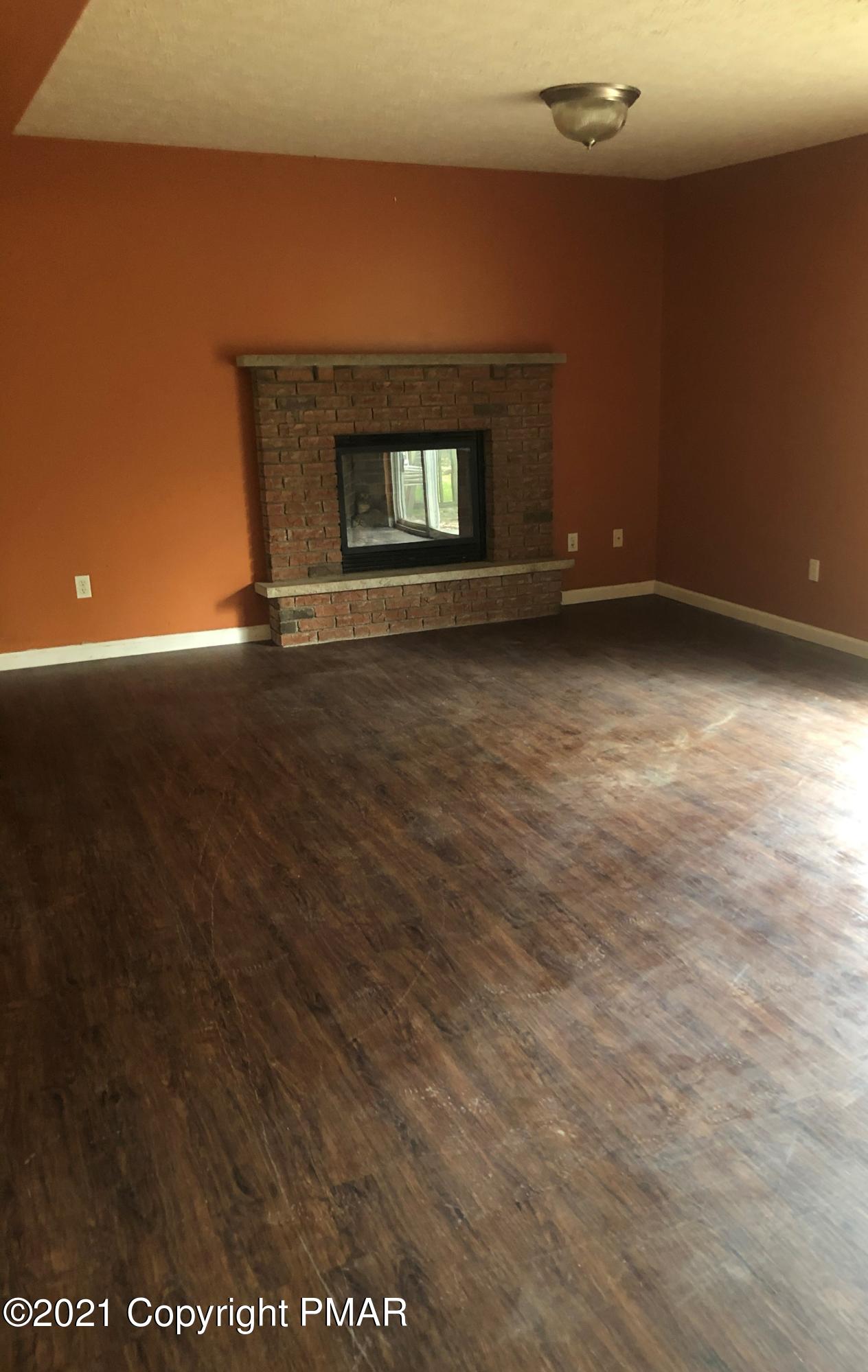 3240 Red Run Road Pocono Summit, PA 18346 - Photo 6 of 15 an empty room with a fireplace
