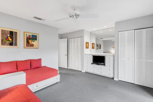 a backyard of a house with plants and large tree