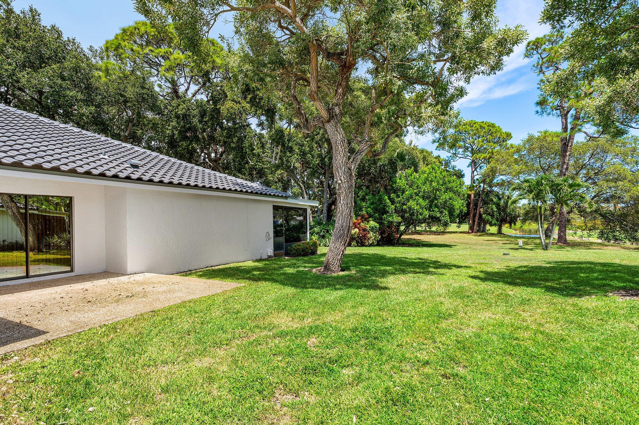 56 Woods Lane Boynton Beach, FL 33436 - Photo 43 of 77 a backyard of a house with plants and large tree