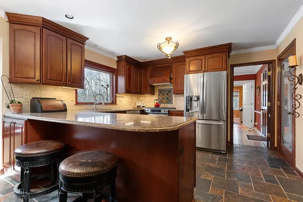 a kitchen with stainless steel appliances granite countertop a sink refrigerator and cabinets
