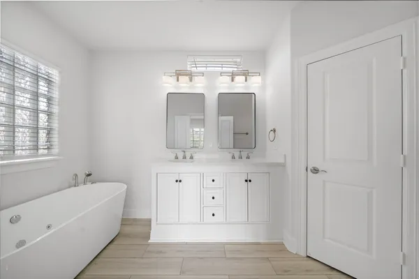 a bathroom with a tub sink and mirror