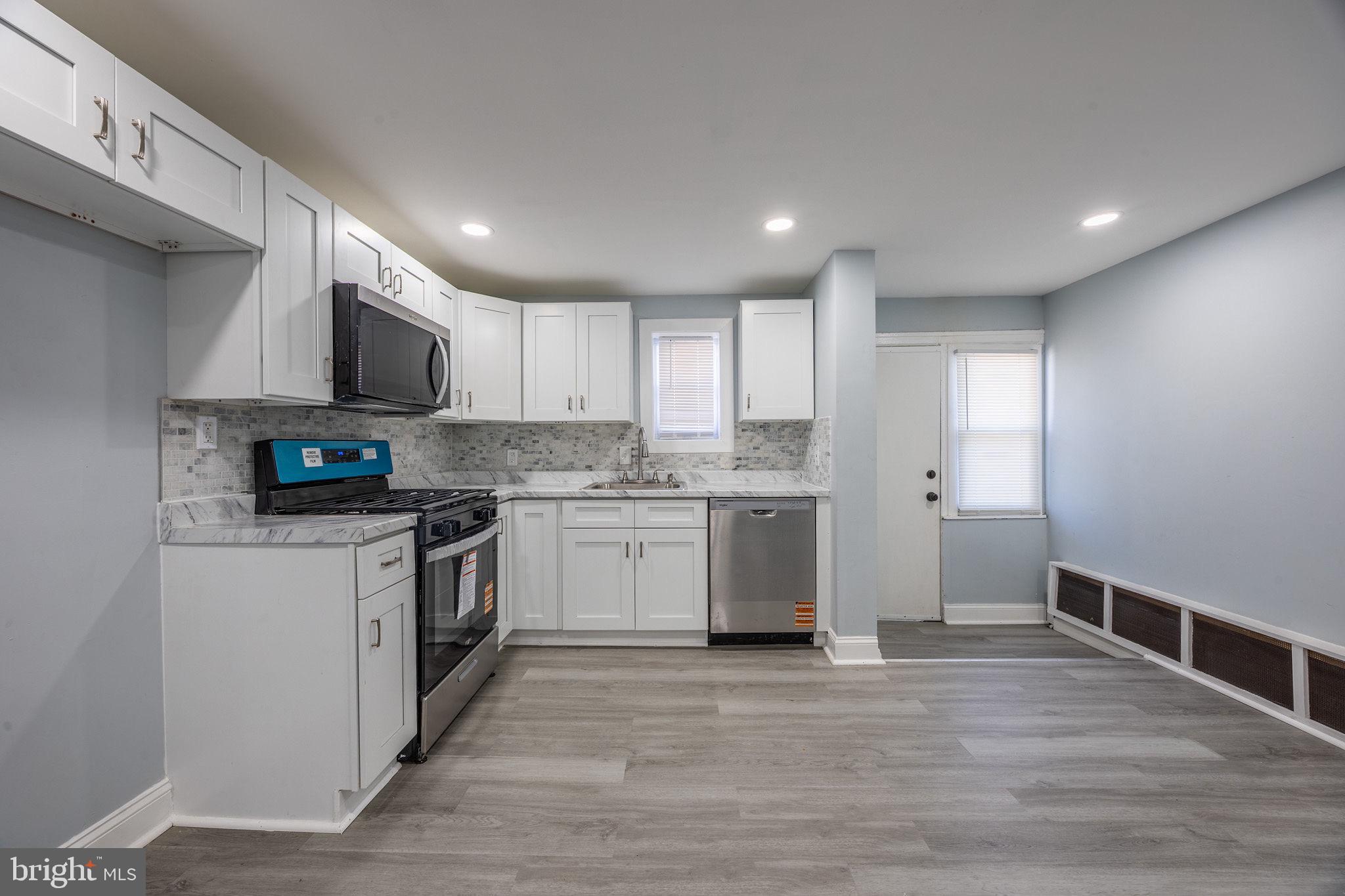 2403 South Edgewood Street Philadelphia, PA 19142 - Photo 15 of 31 a kitchen with granite countertop a sink cabinets and stainless steel appliances