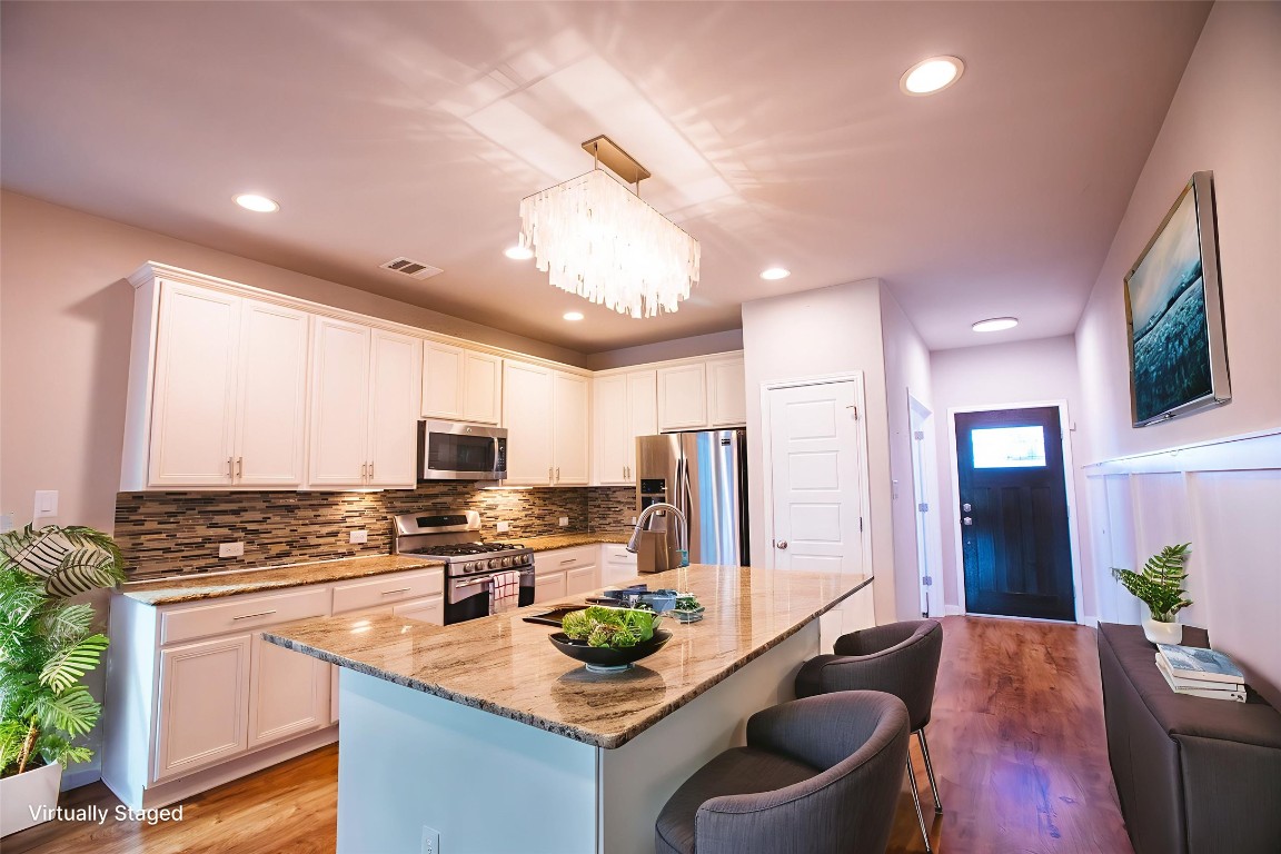 11700 Harpster Bend Austin, TX 78717 - Photo 1 of 1 a kitchen with stainless steel appliances kitchen island granite countertop a stove a sink a refrigerator and a microwave