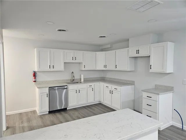 a kitchen with granite countertop a sink a stove and cabinets