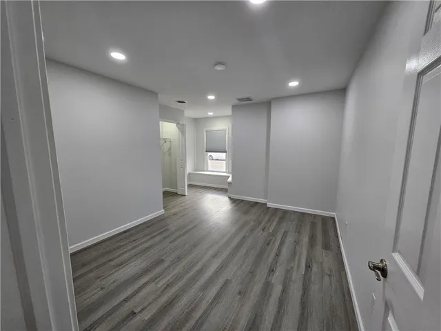a view of empty room with wooden floor