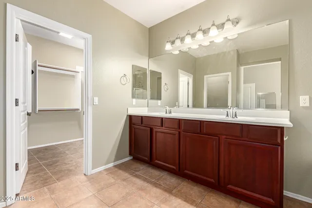 a bathroom with a tub sink double vanity and mirror