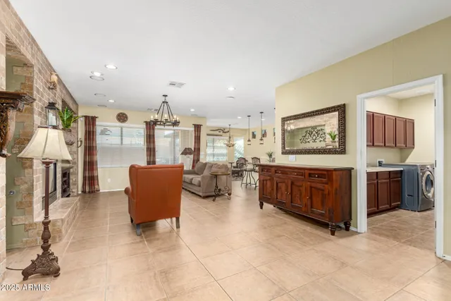 a living room with furniture kitchen view and a chandelier