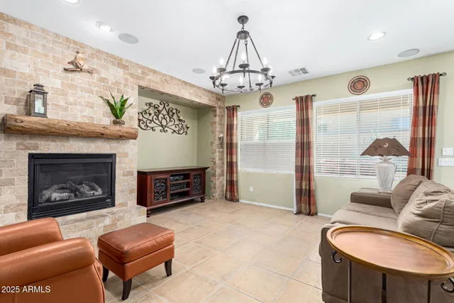a living room with furniture a fireplace and a chandelier