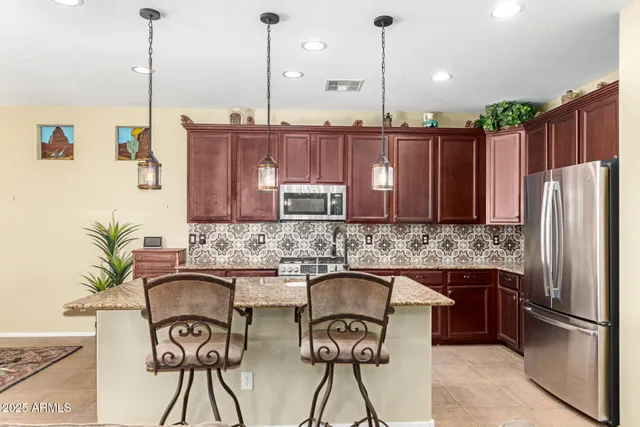 a kitchen with a table chairs refrigerator and microwave