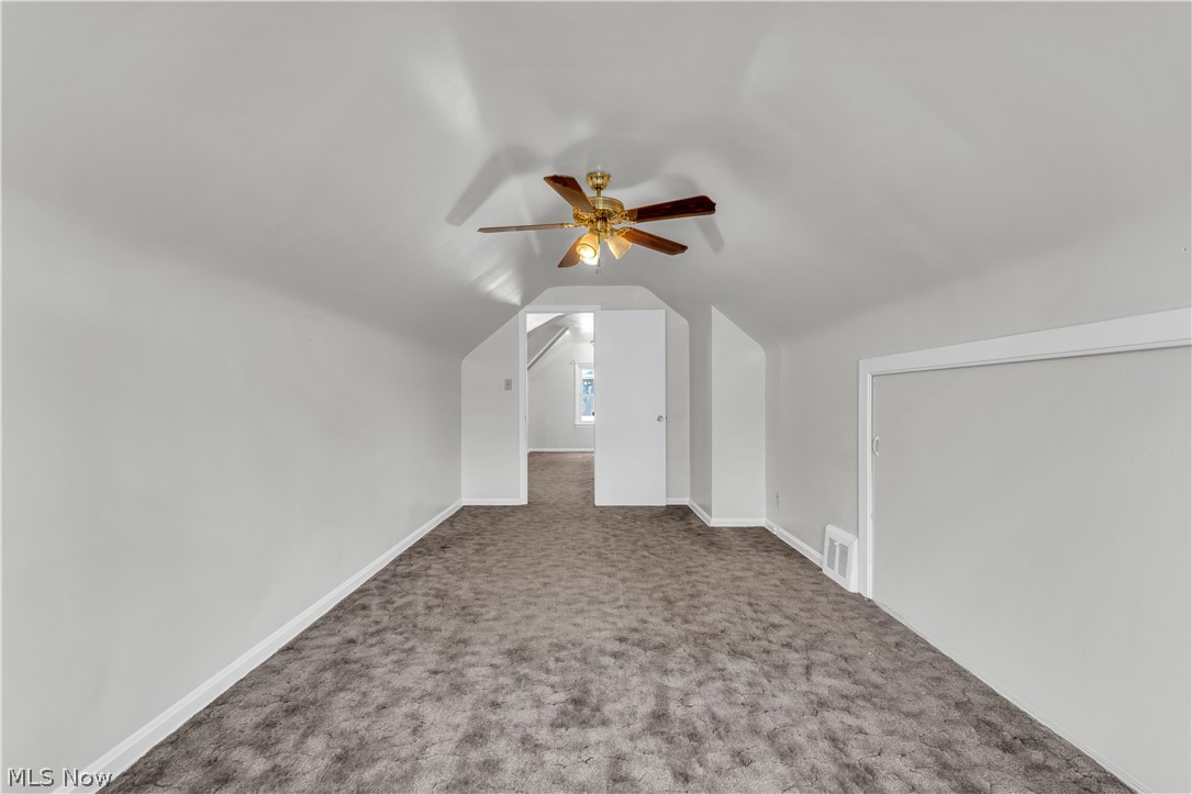 3842 Wallingford Road South Euclid, OH 44121 - Photo 23 of 31 Additional living space featuring ceiling fan, vaulted ceiling, and dark carpet