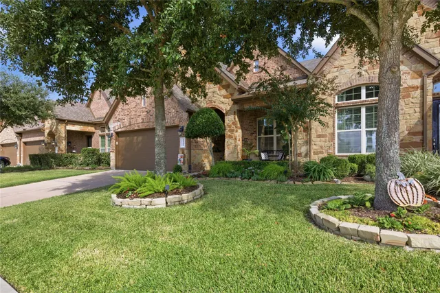 a front view of a house with a yard and fountain