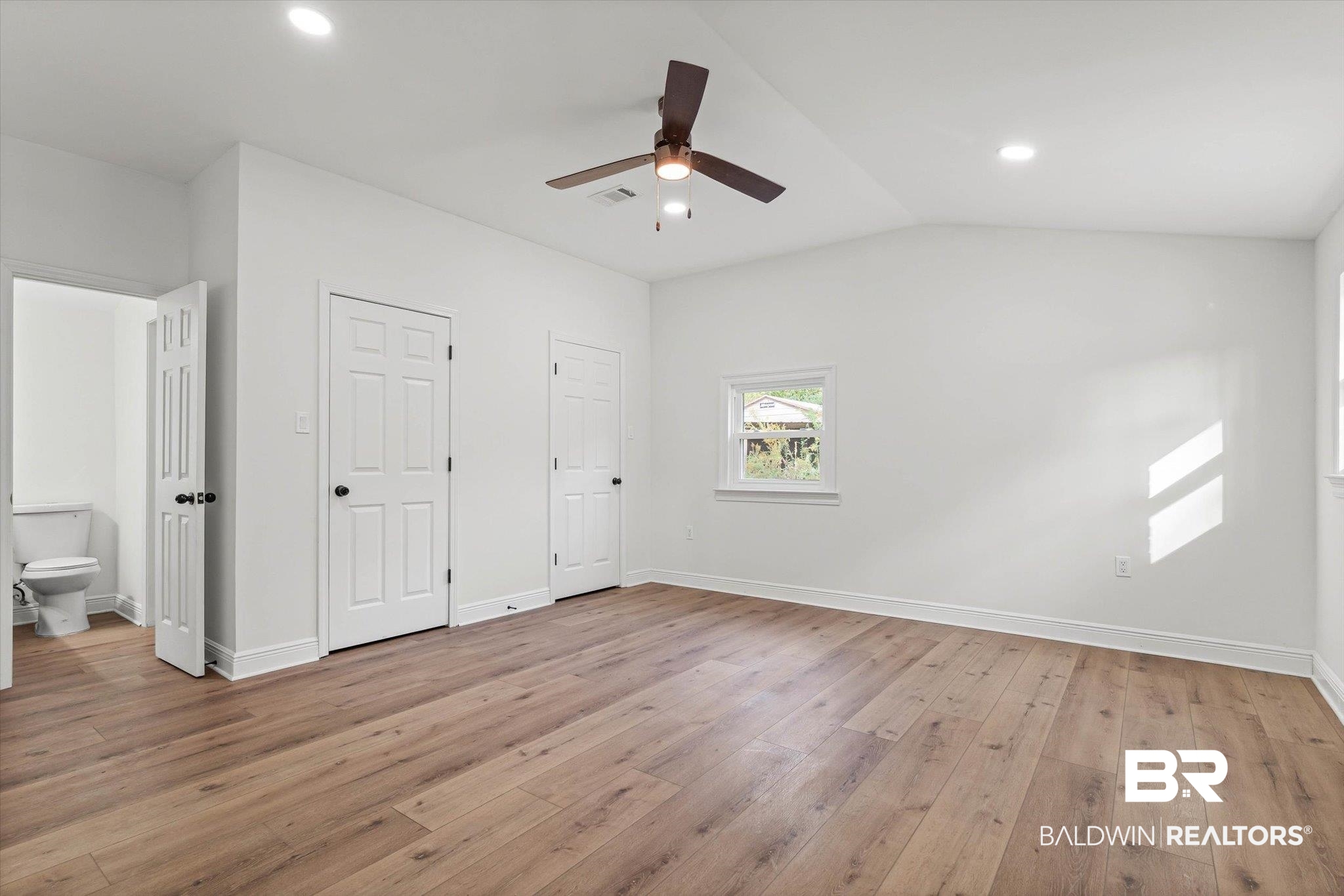 4156 Furman Drive Mobile, AL 36619 - Photo 9 of 24 Unfurnished bedroom featuring light wood-style flooring, multiple closets, vaulted ceiling, ceiling fan, and recessed lighting