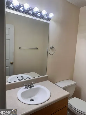 a bathroom with a sink a toilet and mirror
