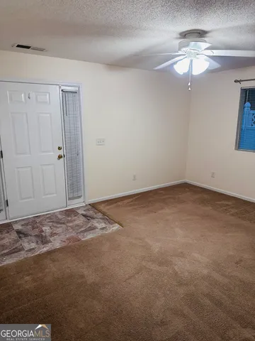 a view of a room with a ceiling fan and a window