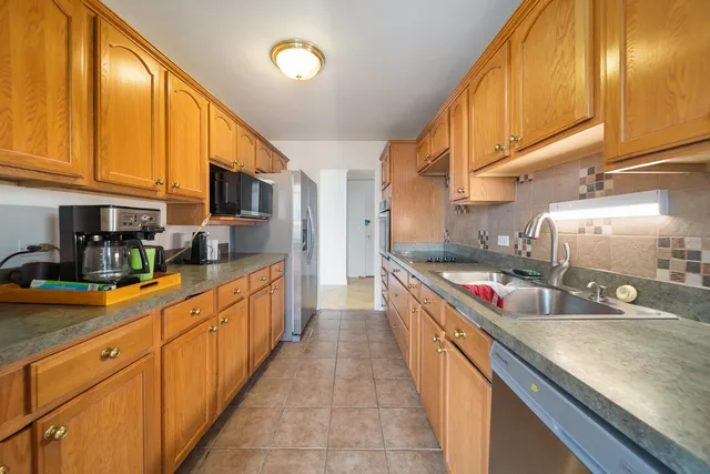 a large kitchen with stainless steel appliances granite countertop a sink and cabinets