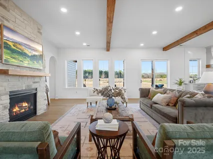 a living room with furniture a fireplace and a large window