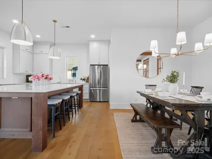 a room with kitchen island a dining table wooden floor and a dining table