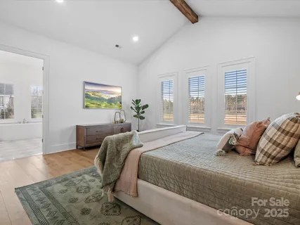 a bedroom with a large bed and a wooden floor