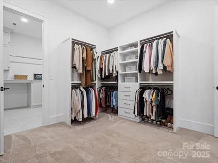 a view of walk in closet with clothes and shoes