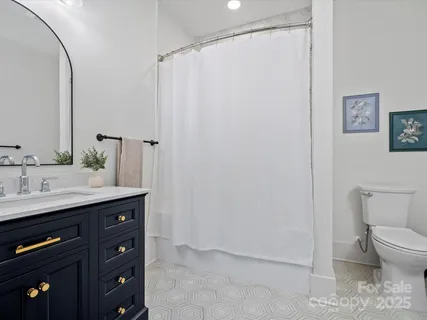 a bathroom with a granite countertop sink a toilet and a mirror