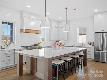 a kitchen with kitchen island a table and chairs in it