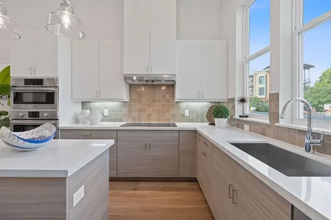 a kitchen with kitchen island granite countertop a sink and a stove top oven