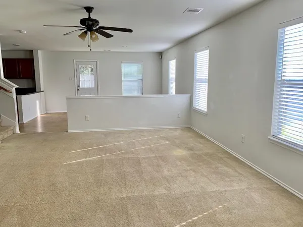 a view of a livingroom with wooden floor and a ceiling fan