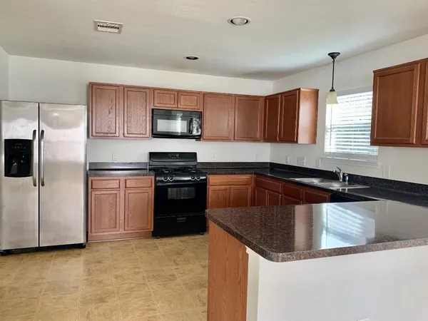 a kitchen with stainless steel appliances granite countertop a sink a stove and a microwave