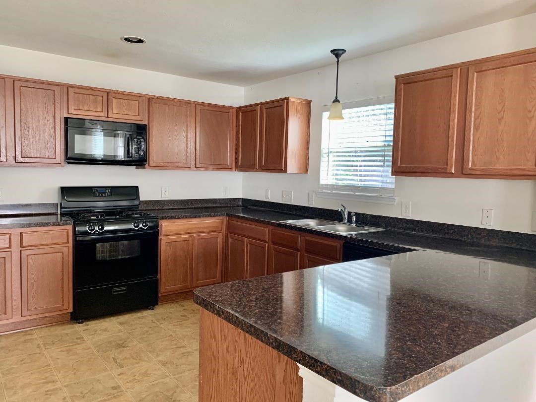 2902 Beacon Grove Street Spring, TX 77389 - Photo 9 of 22 a kitchen with stainless steel appliances granite countertop a sink a stove and a microwave