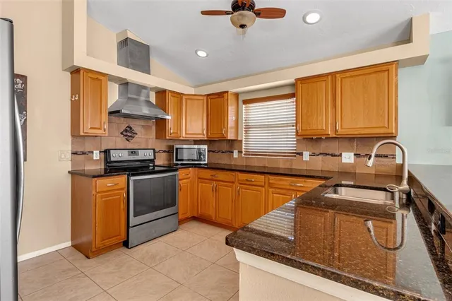 a kitchen with granite countertop a counter space dining table stainless steel appliances and cabinets