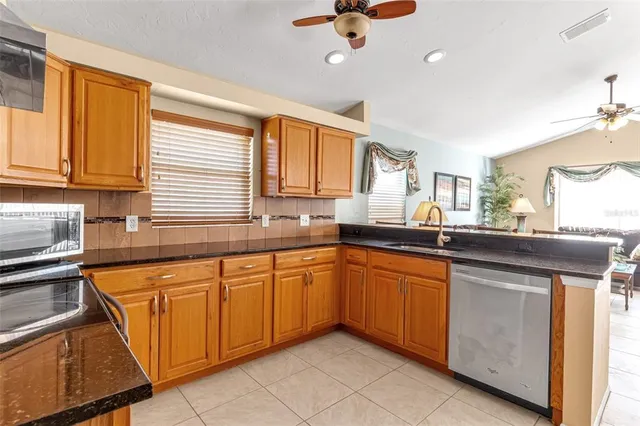 a kitchen with stainless steel appliances granite countertop a refrigerator and a stove